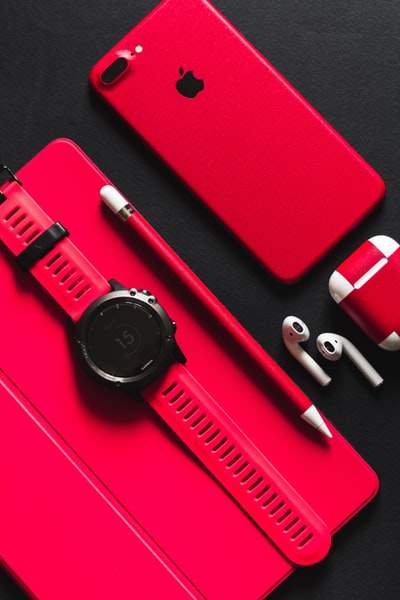 智能手表、触控笔、AirPods和黑色表面上的产品红色iPhone7